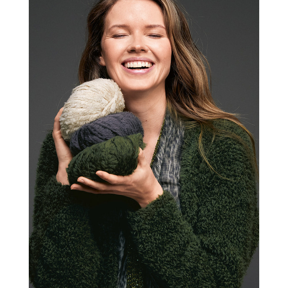 Inspiratiefoto bij Lana Grossa Pelliccia 016 Bordeaux: vrouw met zachte garenbollen in neutrale en groene kleuren