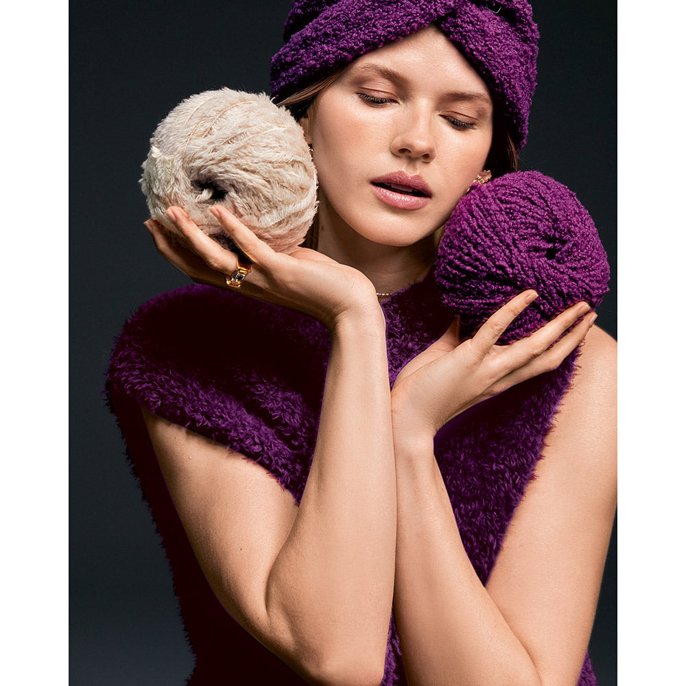 Inspiratiefoto bij Lana Grossa Pelliccia 016 Bordeaux: vrouw toont paarse turbanmuts en pluizige garenbollen
