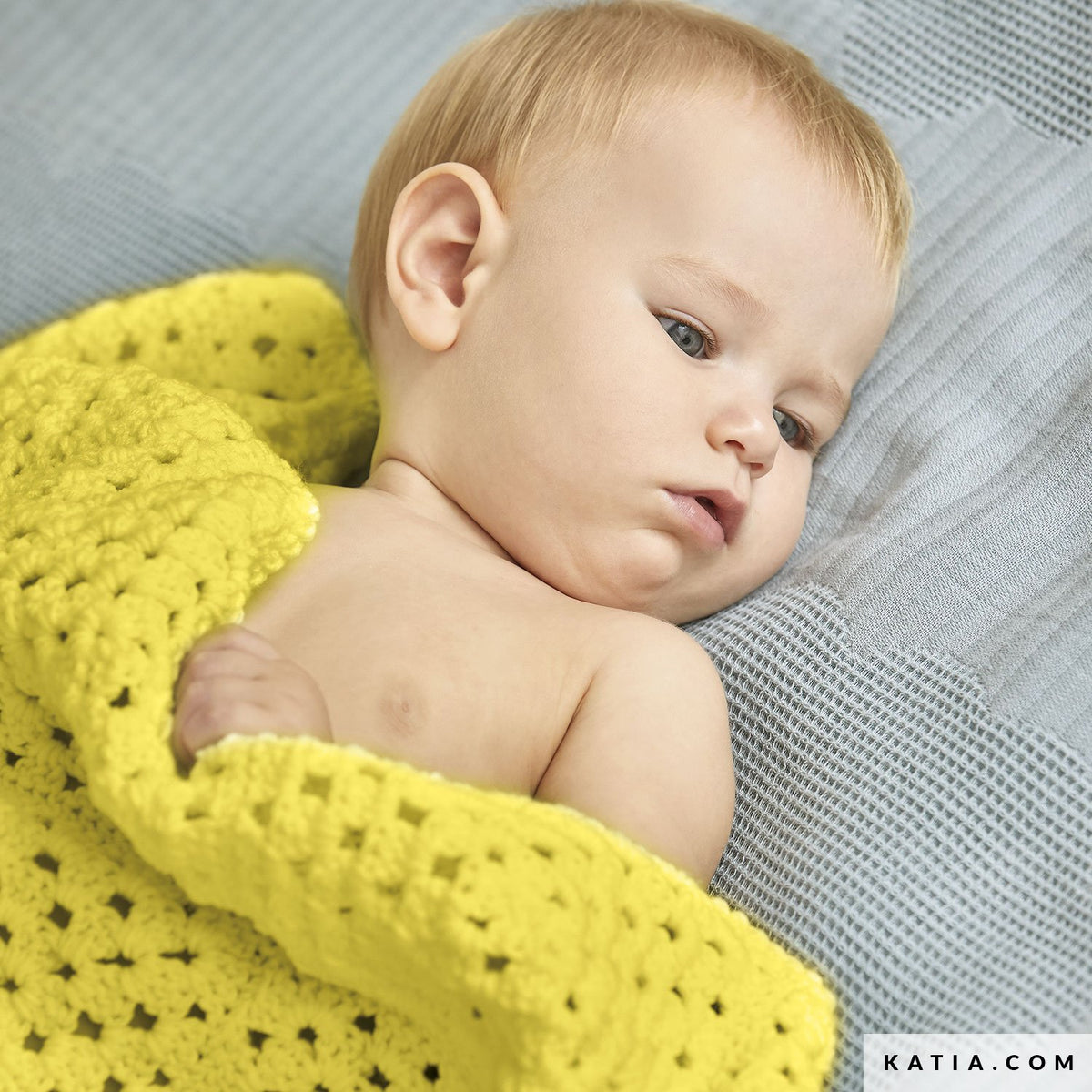 Baby onder een gele Katia The Basic gehaakte deken