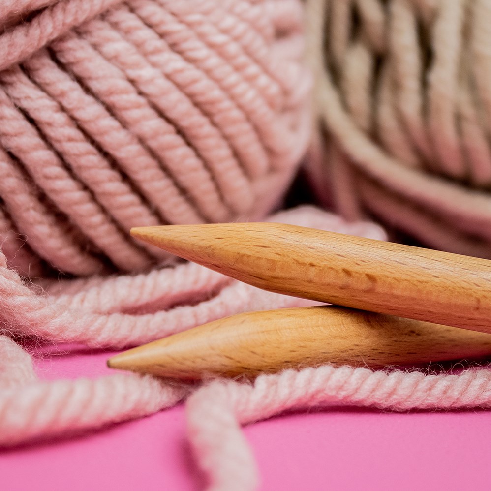 Knitting needles with threads, beige yarn. Hobby for women concept.  Knitting accessories Stock Photo by paralisart